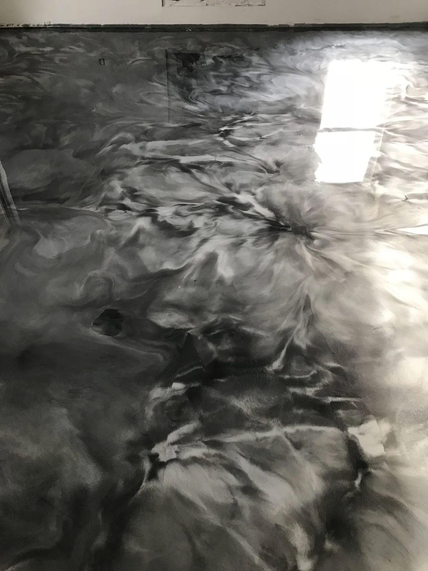 Charcoal and white marbled metallic epoxy floor finish close-up