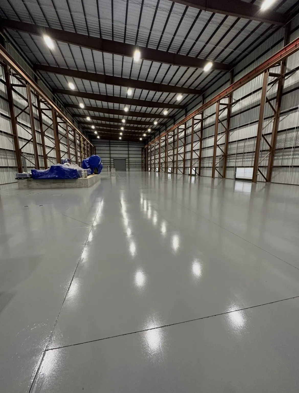 Gray epoxy coated commercial warehouse floor with steel racking